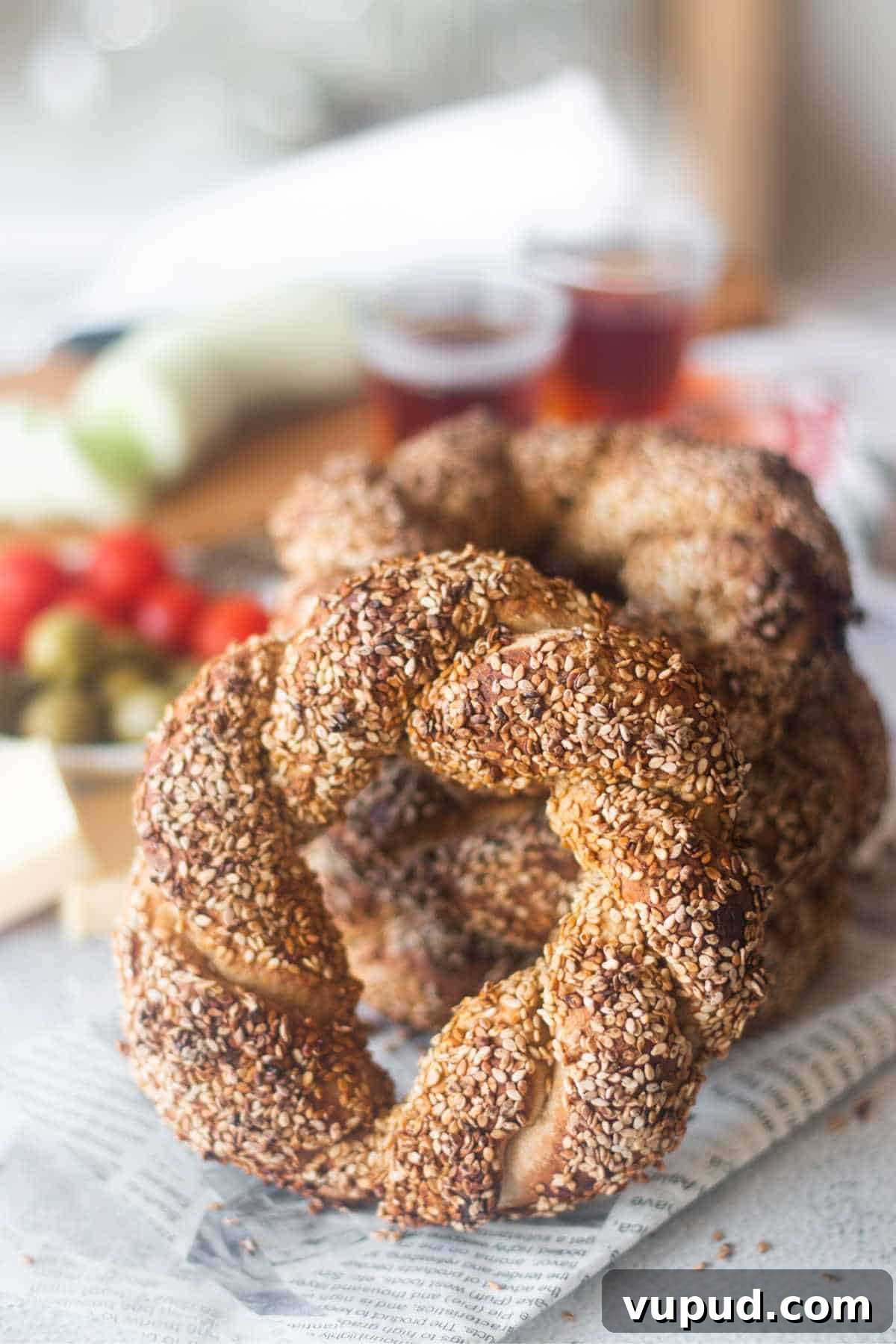 How to Make Turkish Simit: Crispy Bagel-Style Bread Recipe 10 sesame crusted simit bread in the front with stacked bread behind it