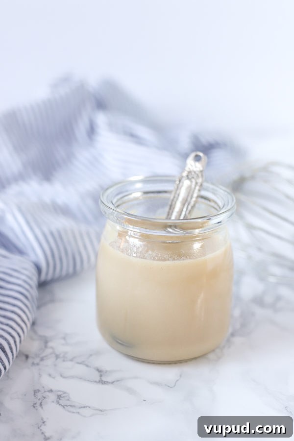 Homemade Sweetened Condensed Milk: Simple Stovetop Recipe 3 glass jar of homemade sweetened condensed milk with a spoon
