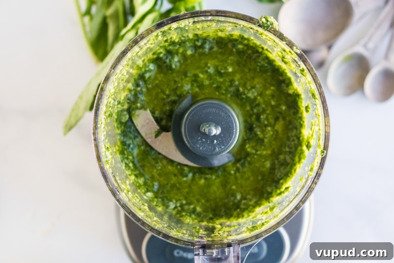 Homemade Nut-Free Pesto Recipe: Flavorful Dairy-Free Sauce 5 Nut free pesto sauce in a food processor, fully blended.