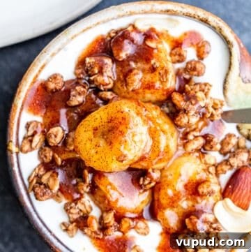 Pan-Fried Cinnamon Bananas with Maple Glaze Recipe 12 Overhead shot of bananas on top of granola and yogurt in small tan bowl.