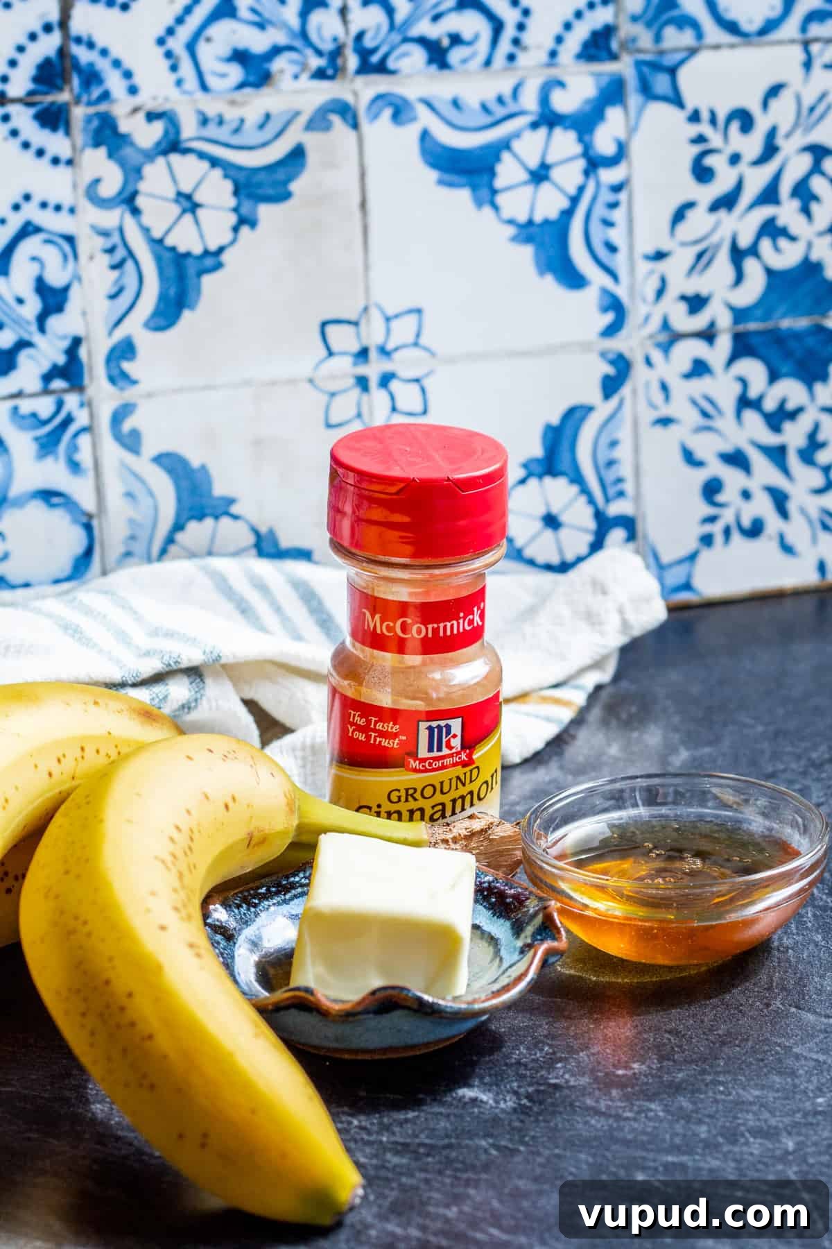 Pan-Fried Cinnamon Bananas with Maple Glaze Recipe 3 Ingredients laid out on blue counter in small glass bowls and containers.