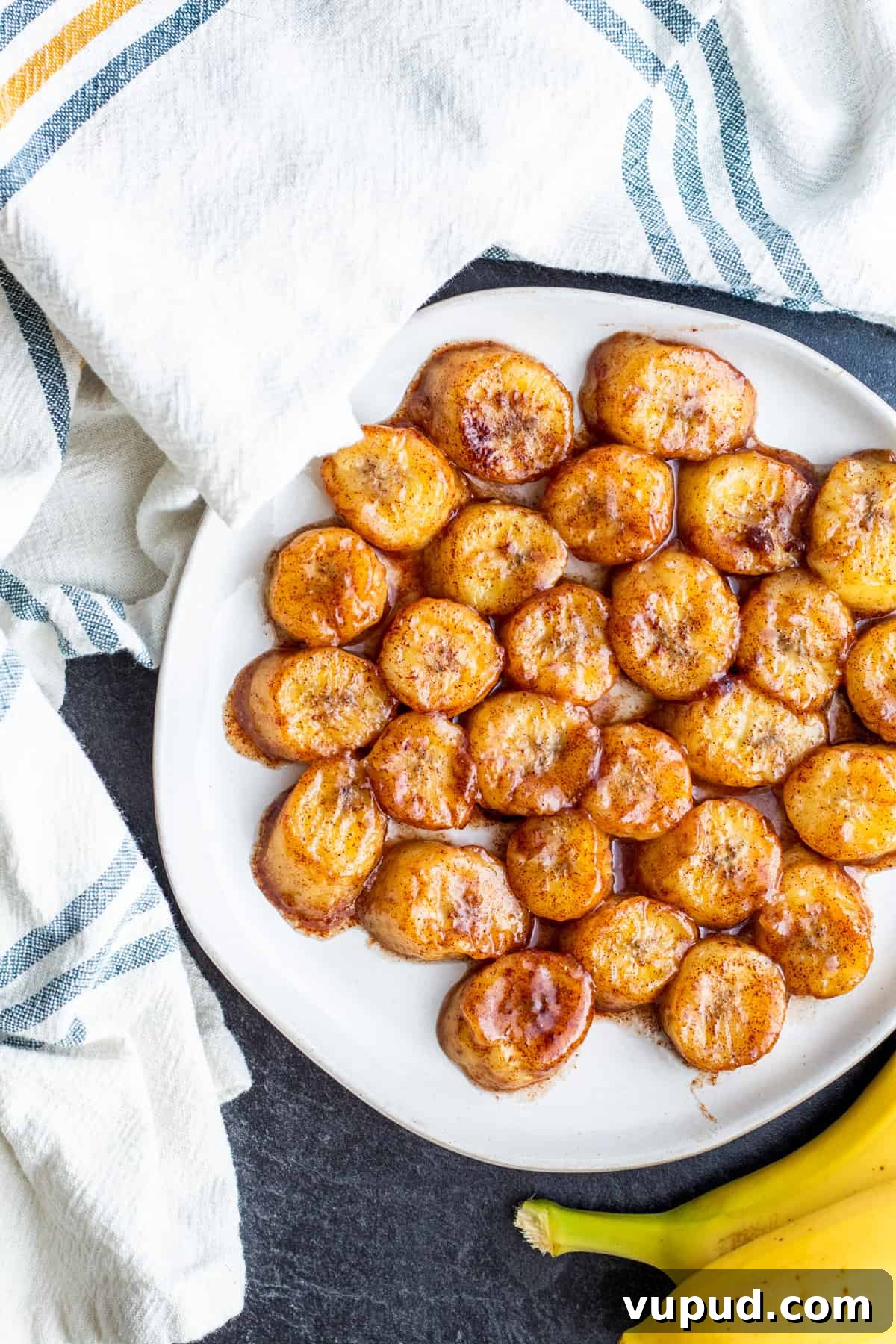 Pan-Fried Cinnamon Bananas with Maple Glaze Recipe 6 Overhead shot of fried bananas on white plate.