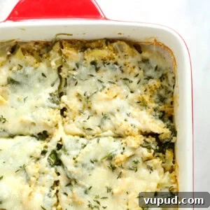 cheesy spinach casserole in a red and white dish.