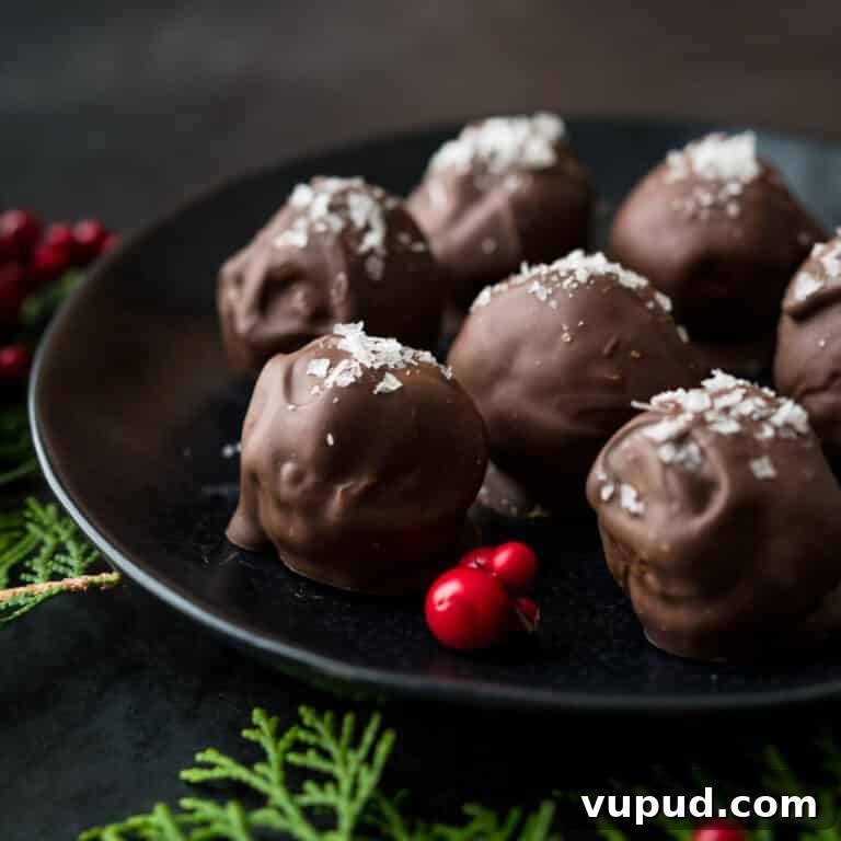 No-Bake Peanut Butter Rice Krispie Balls Dipped in Dark Chocolate 17 chocolate peanut butter balls with rice krispies on a black serving platter.
