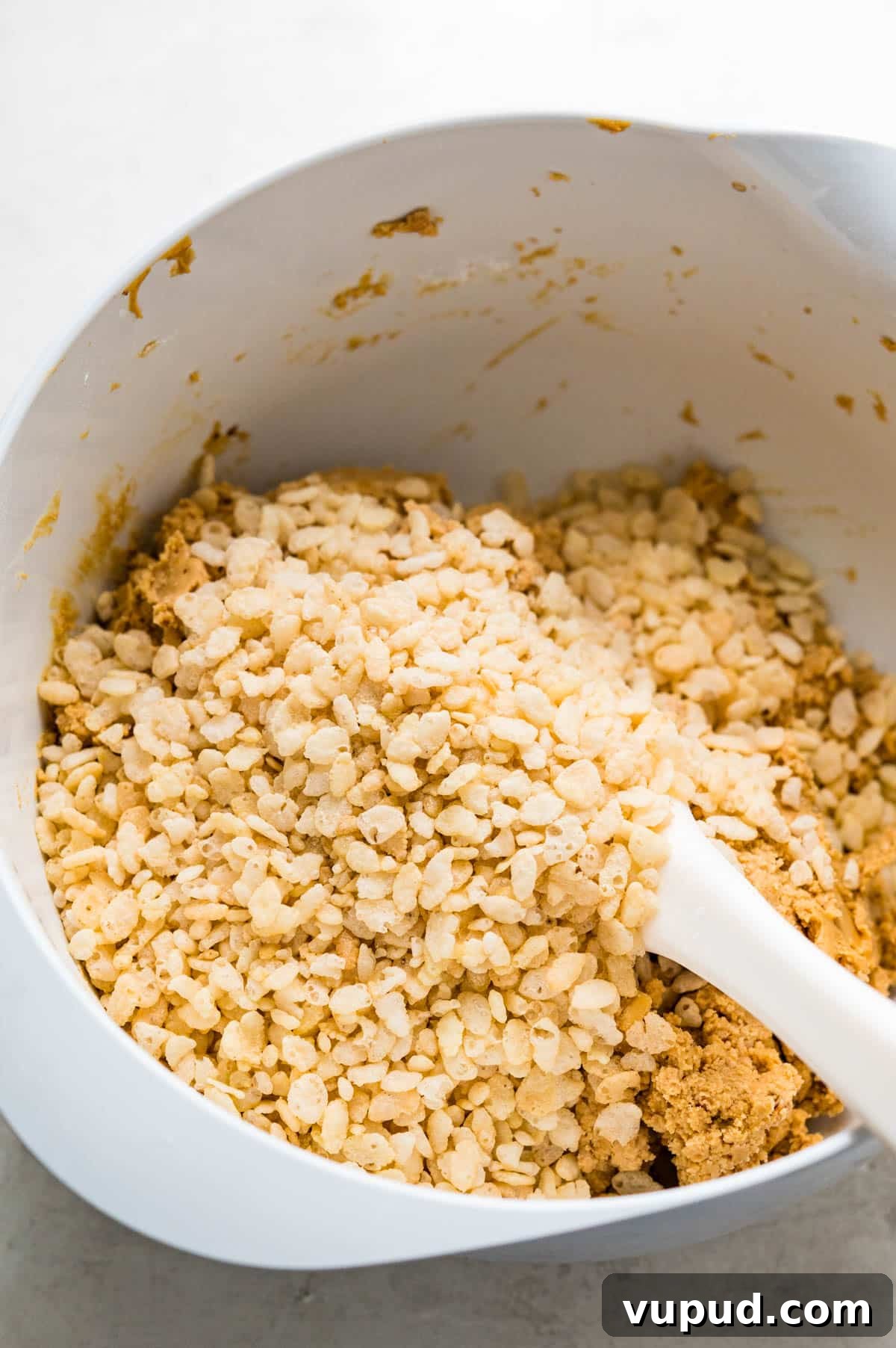 No-Bake Peanut Butter Rice Krispie Balls Dipped in Dark Chocolate 6 adding Rice Krispies cereal to the peanut butter mixture.