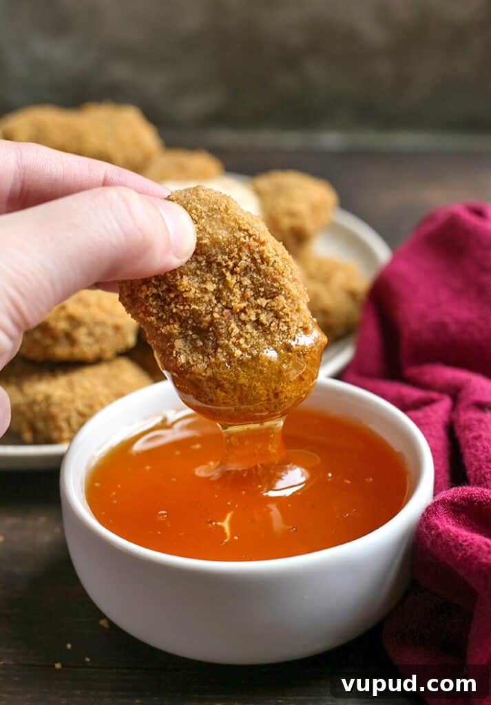 Crispy Gluten-Free Chicken Nuggets Recipe for Kids and Adults 6 paleo chicken nugget dipping in a bowl of honey