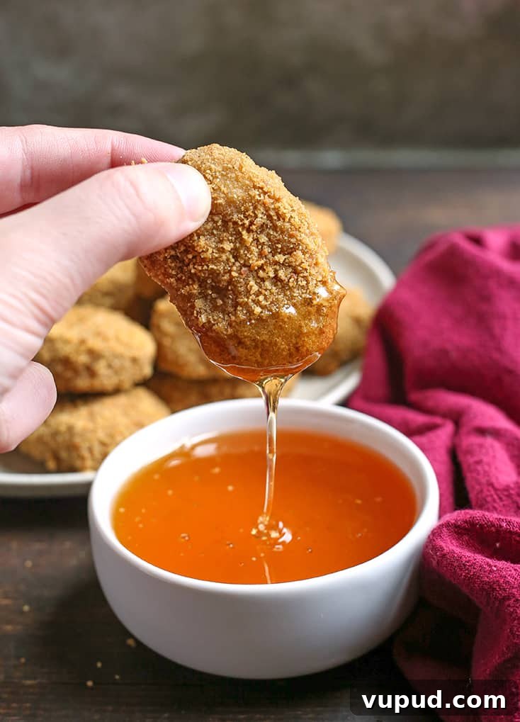 Crispy Gluten-Free Chicken Nuggets Recipe for Kids and Adults 7 paleo chicken nuggets dipping in honey with a drizzle