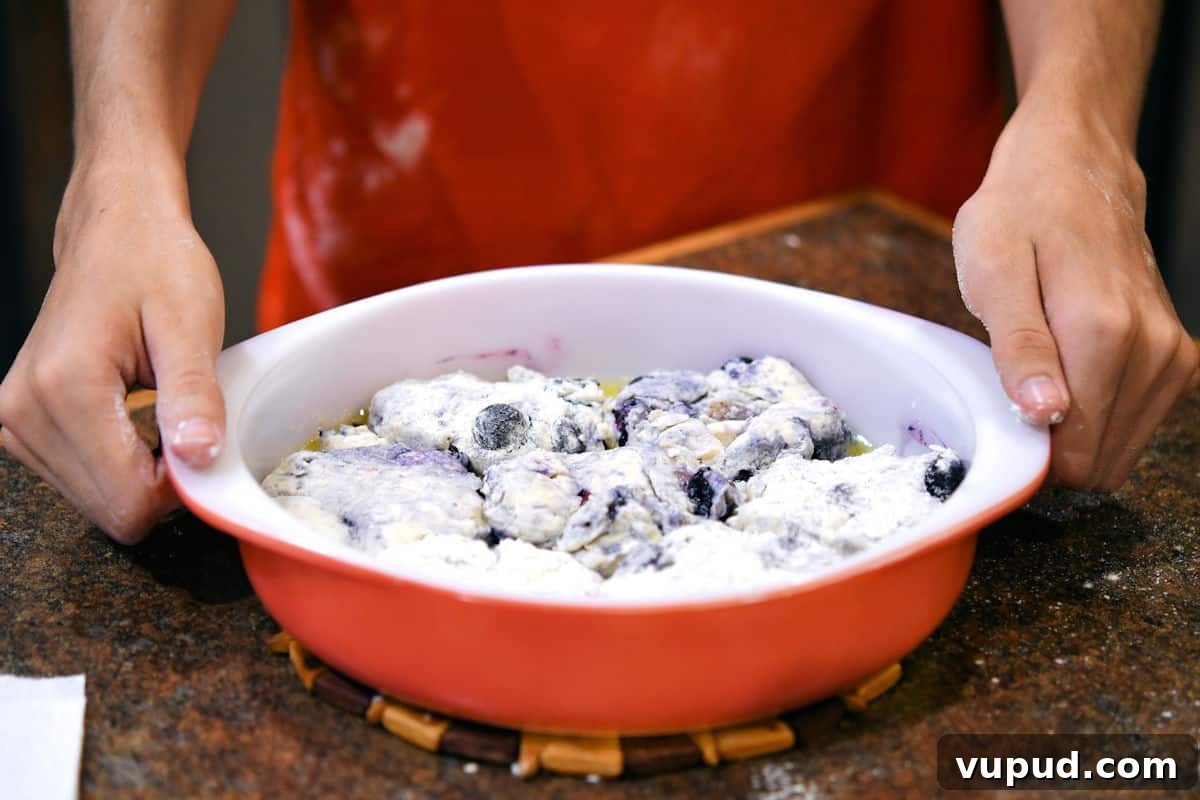 Buttermilk Bisquick Blueberry Biscuits Recipe for Flaky Results 10 blueberry biscuits cut out in a cake pan, ready for the oven