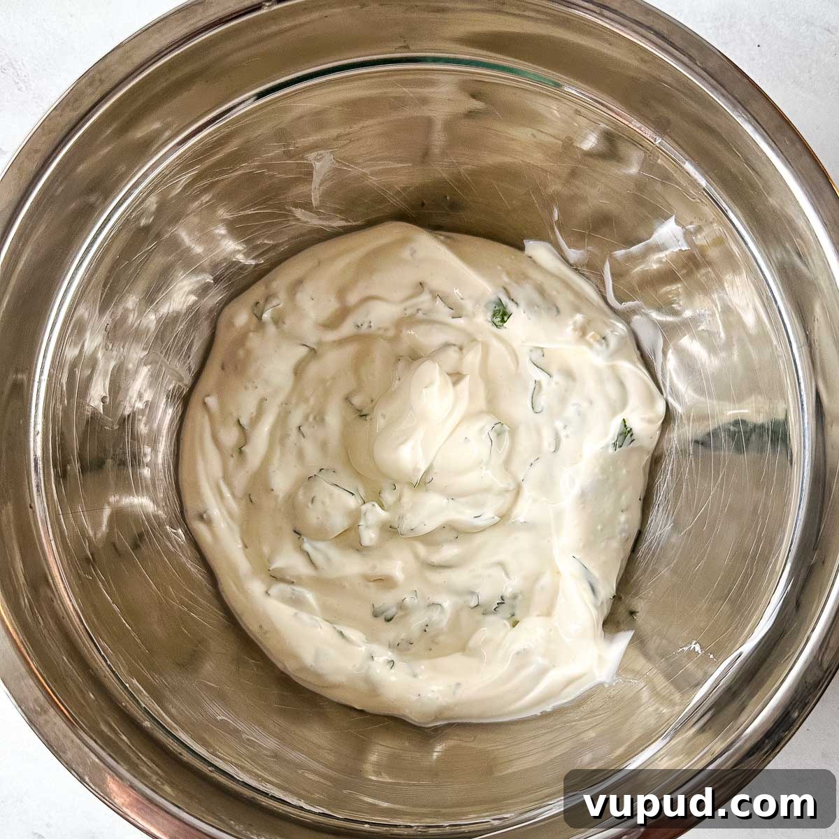 Creamy Cilantro-Lime Crema Recipe for Tacos & Bowls 7 Cilantro lime crema in a silver bowl.