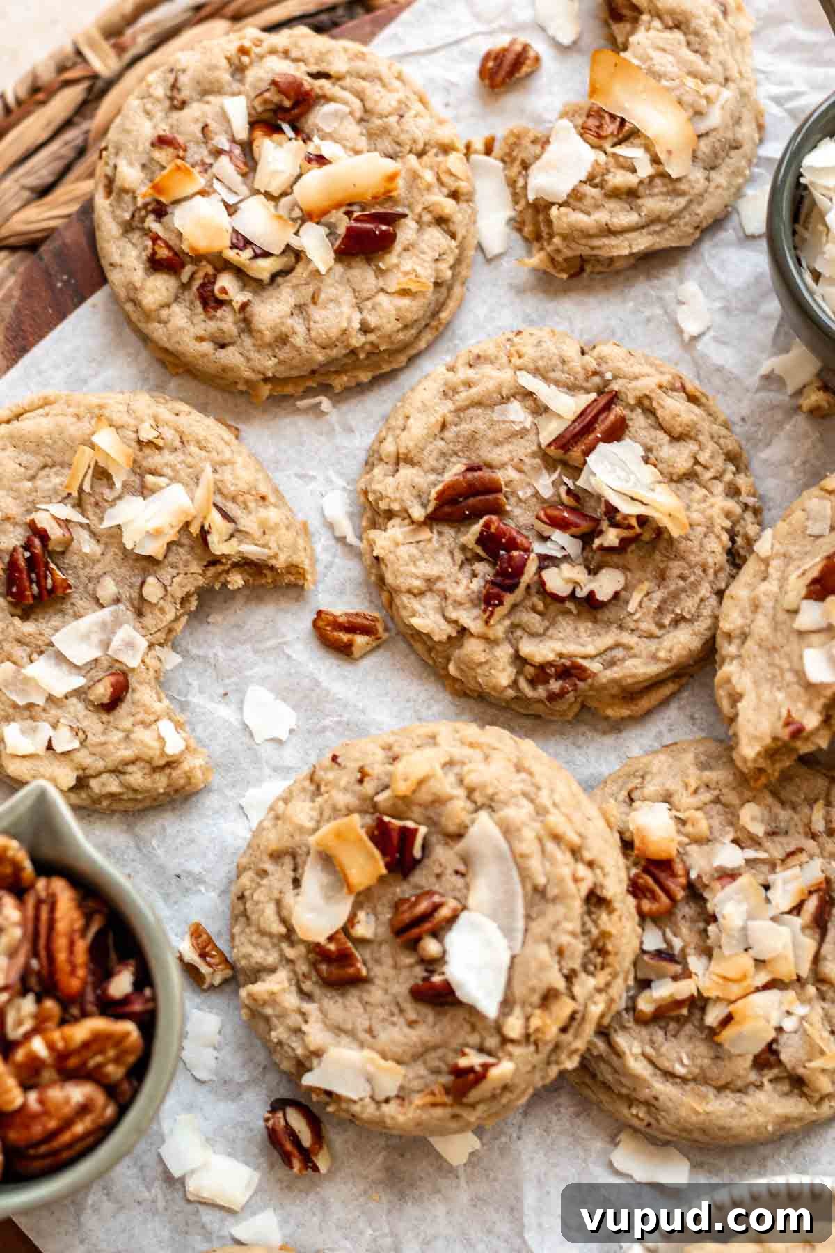 Chewy Coconut Pecan Cookies Recipe for Crispy Edges and Gooey Center 4 An array of coconut cookies on parchment paper.