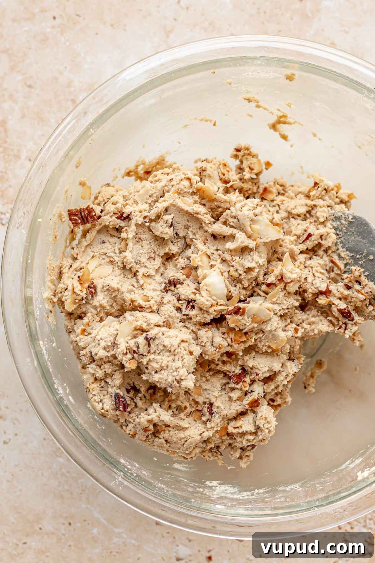 Chewy Coconut Pecan Cookies Recipe for Crispy Edges and Gooey Center 9 A spatula folds pecans and coconut into cookie dough.