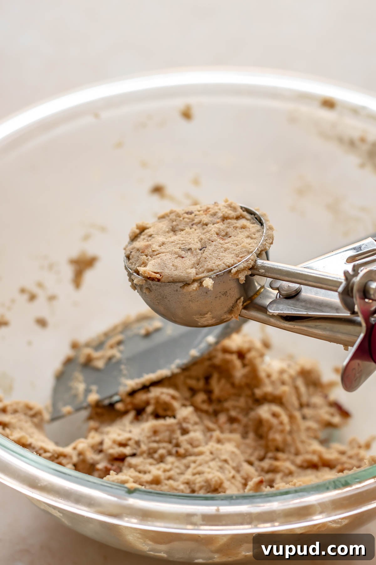 Chewy Coconut Pecan Cookies Recipe for Crispy Edges and Gooey Center 10 A cookie scoop full of cookie dough.