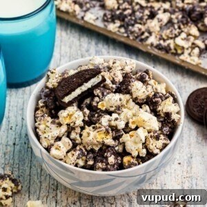 Oreo Popcorn Recipe: Creamy Chocolate Cookie Popcorn Treat 13 Popcorn combined with melted white chocolate and Oreo cookies crushed, with glasses of milk on the table.