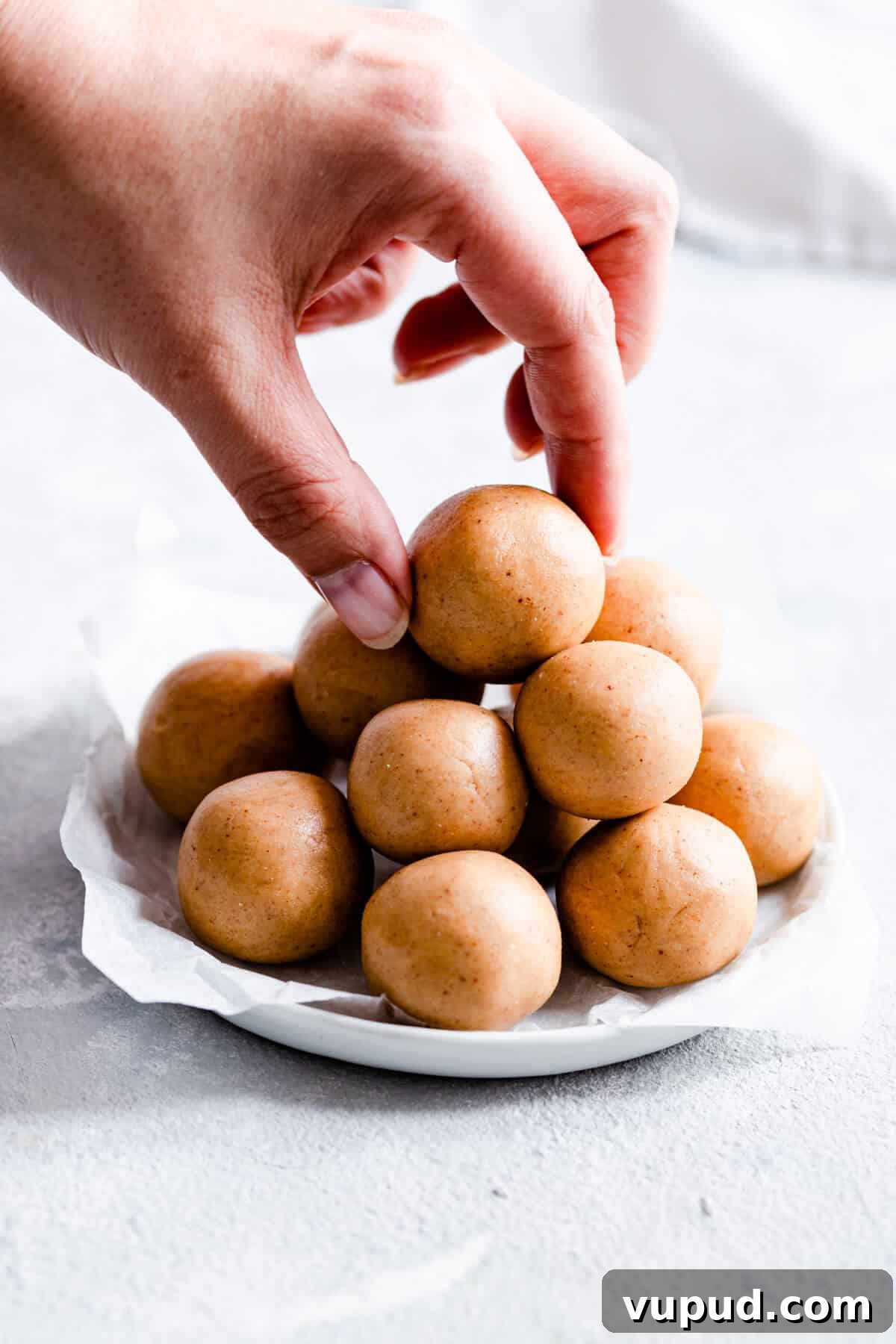 Peanut Butter Energy Balls: 3-Ingredient No-Bake Snack 7 close up of a hand reaching out to peanut butter energy bites