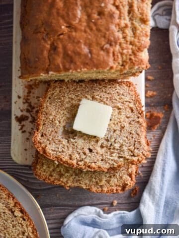 A pat of butter is on a slice of the banana bread with pancake mix.