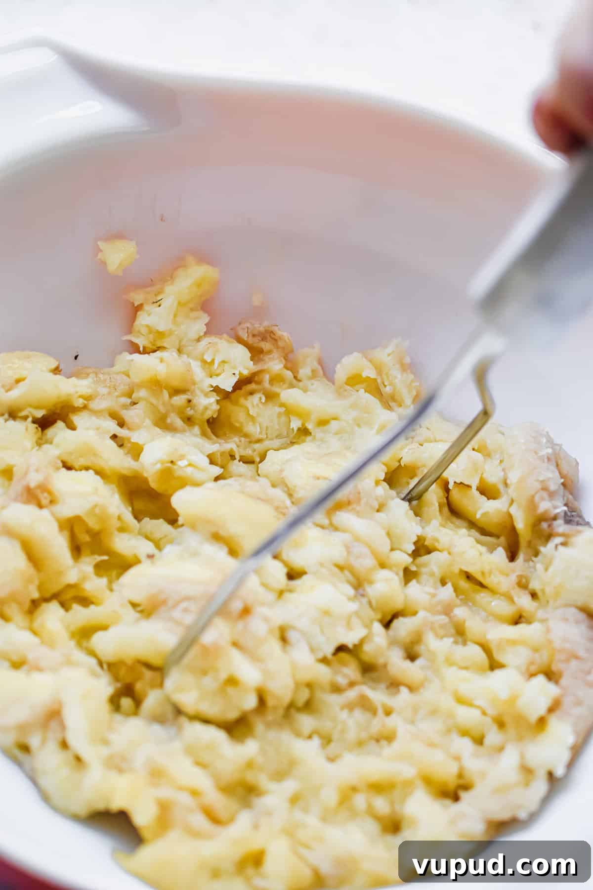 4-Ingredient Banana Bread from Cake Mix — Quick Recipe 4 The bananas are being mashed with a potato masher