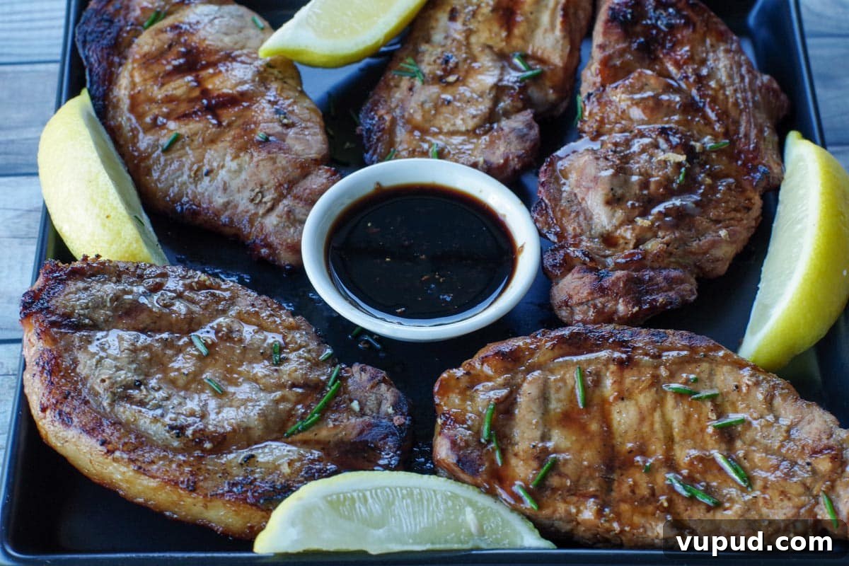 Zesty Mandarin Orange Salad Recipe with Citrus Vinaigrette 8 5 pieces of marinated pork on a black platter with lemon wedges and a dish of soy sauce in the middle