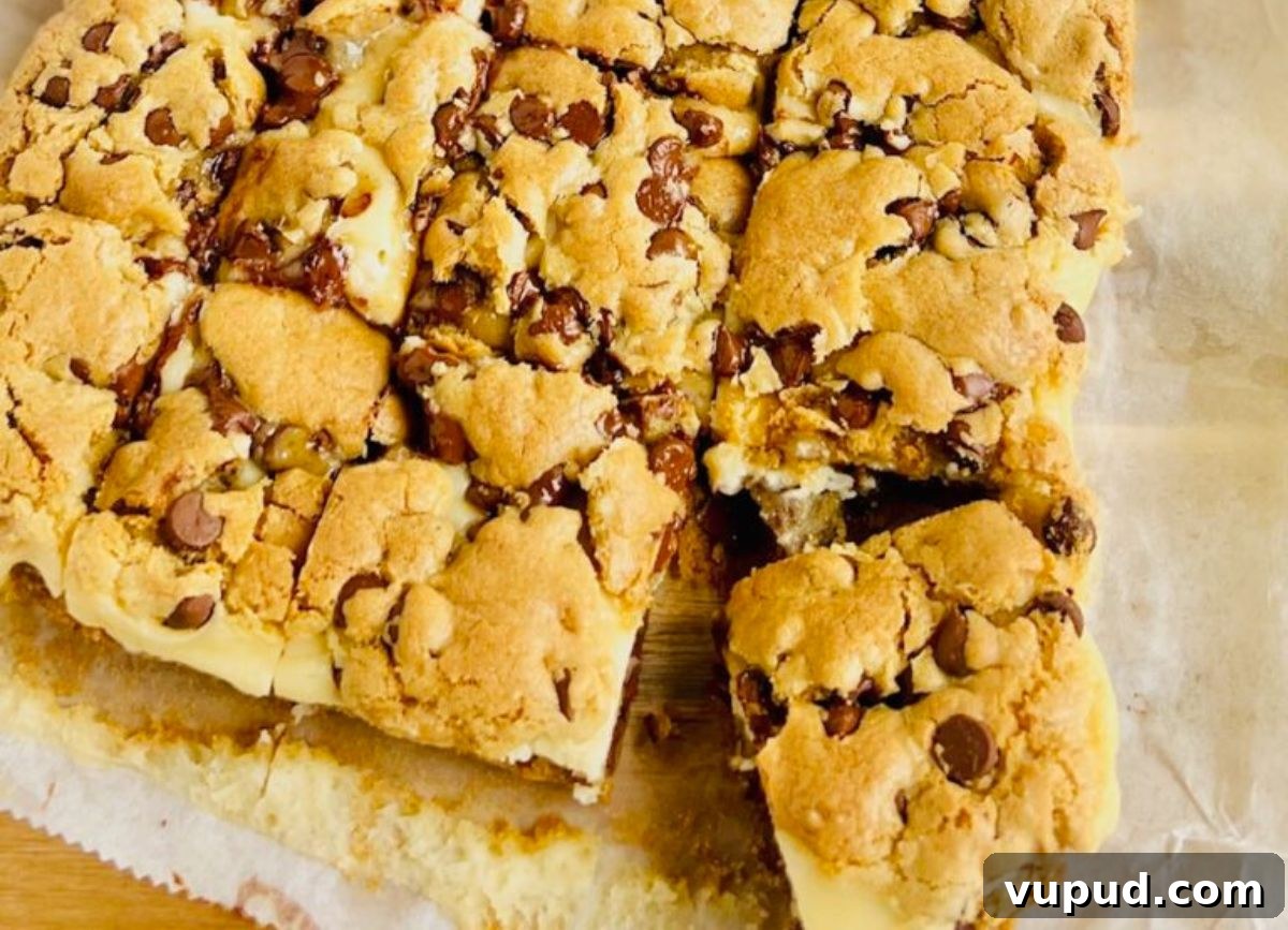 Chewy Chocolate Chip Cream Cheese Bars Recipe 2 A few Chocolate Chip Cream Cheese Bars on a piece of parchment paper.