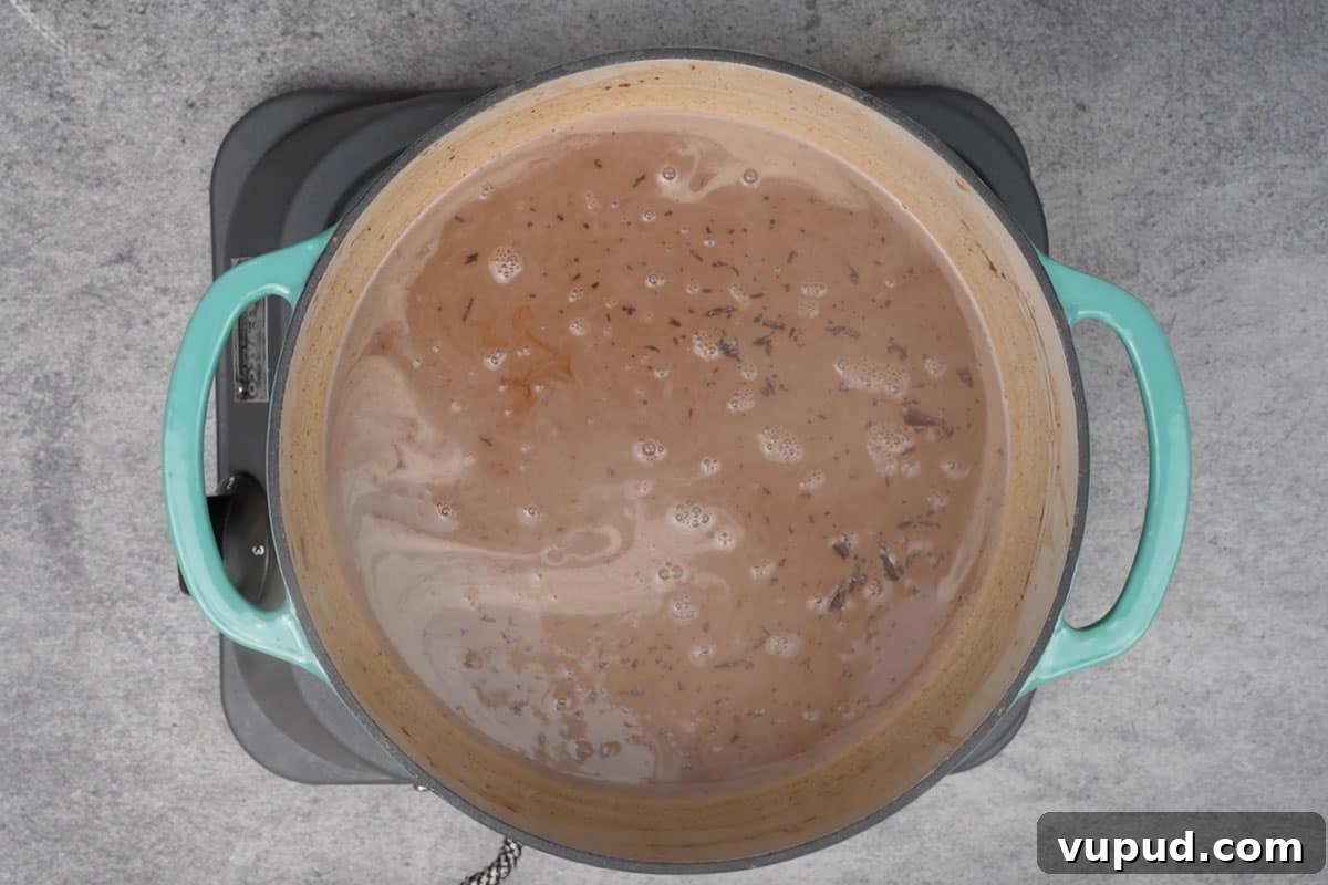 Pumpkin Spice Hot Chocolate: Cozy Autumn Cocoa Recipe 4 Dark chocolate and vanilla extract added to the pan.