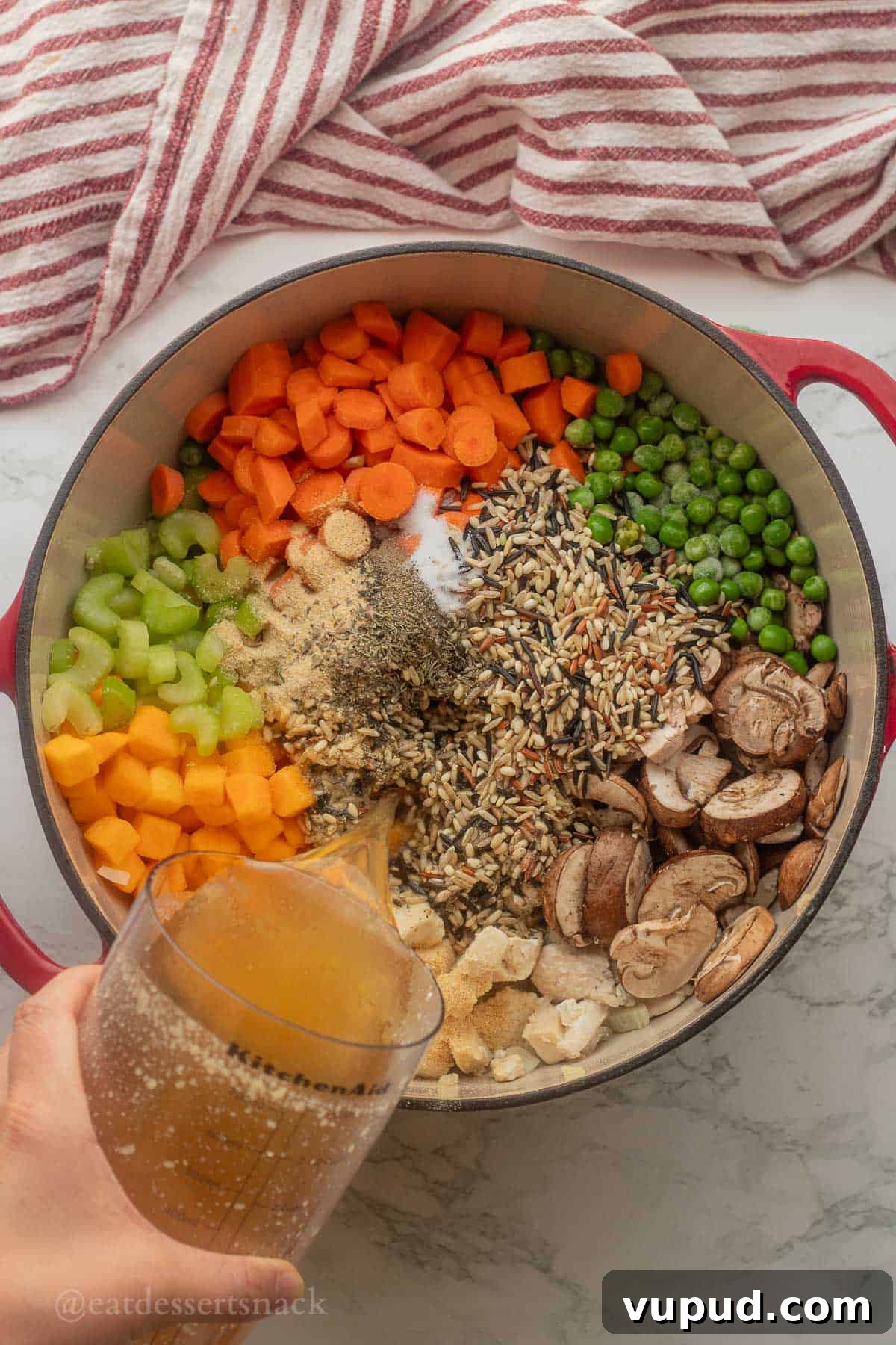 Creamy Chicken and Wild Rice Soup Recipe for Cozy Comfort 5 Pouring chicken broth into pot of raw vegetables.