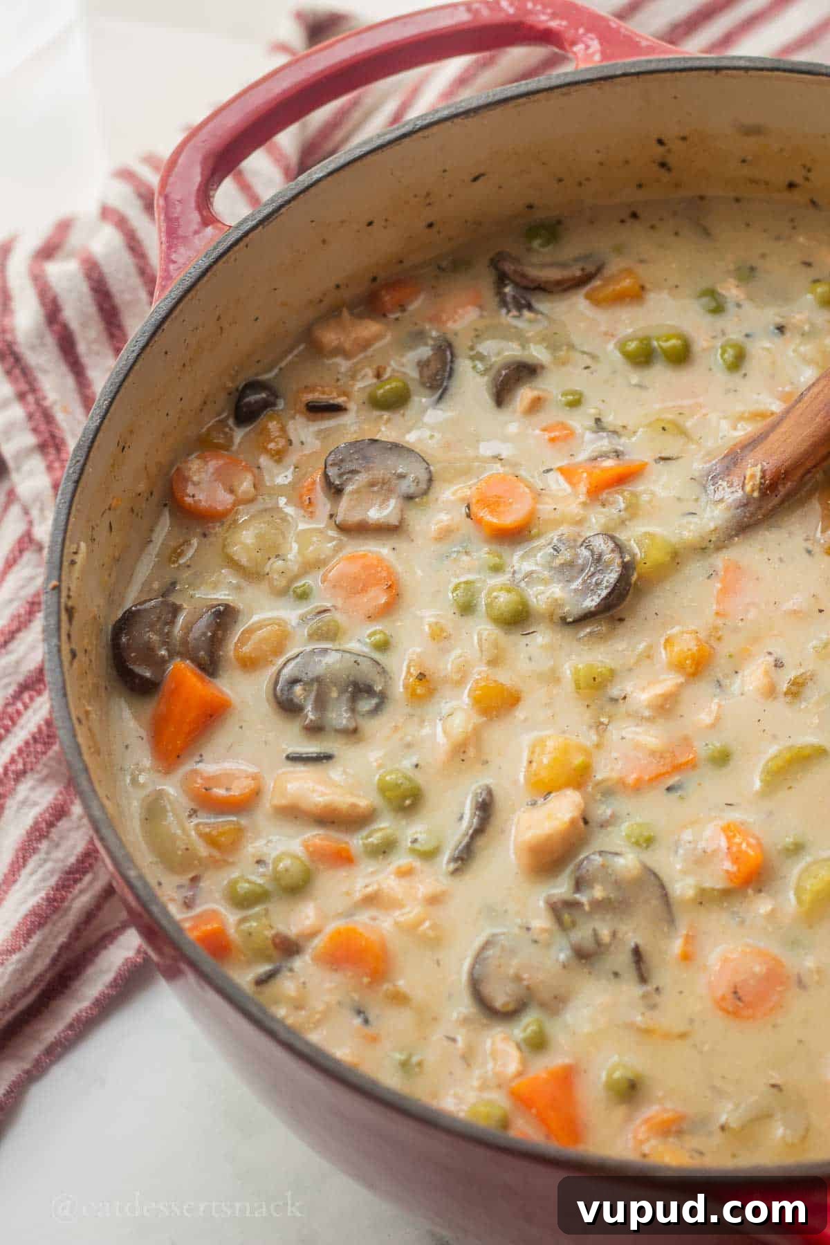 Creamy Chicken and Wild Rice Soup Recipe for Cozy Comfort 8 Pot with creamy wild rice soup and wooden spoon in it.