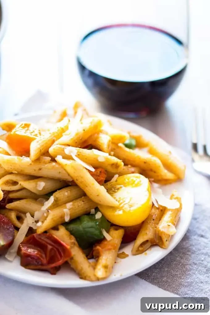 One-Pot Tomato Pesto Pasta Recipe for Quick Weeknight Meals 6 tomato and pesto pasta on a white plate with a glass of red wine
