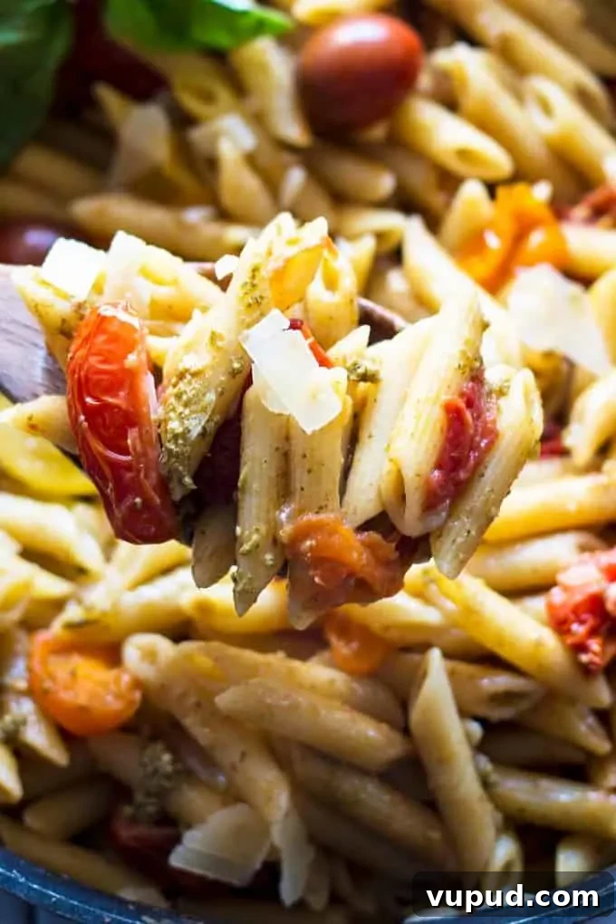 One-Pot Tomato Pesto Pasta Recipe for Quick Weeknight Meals 5 tomato and pesto pasta on a wooden spoon