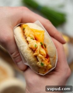 Scrambled Egg Sandwich overhead shot of two hands holding scrambled egg sandwich showing filling