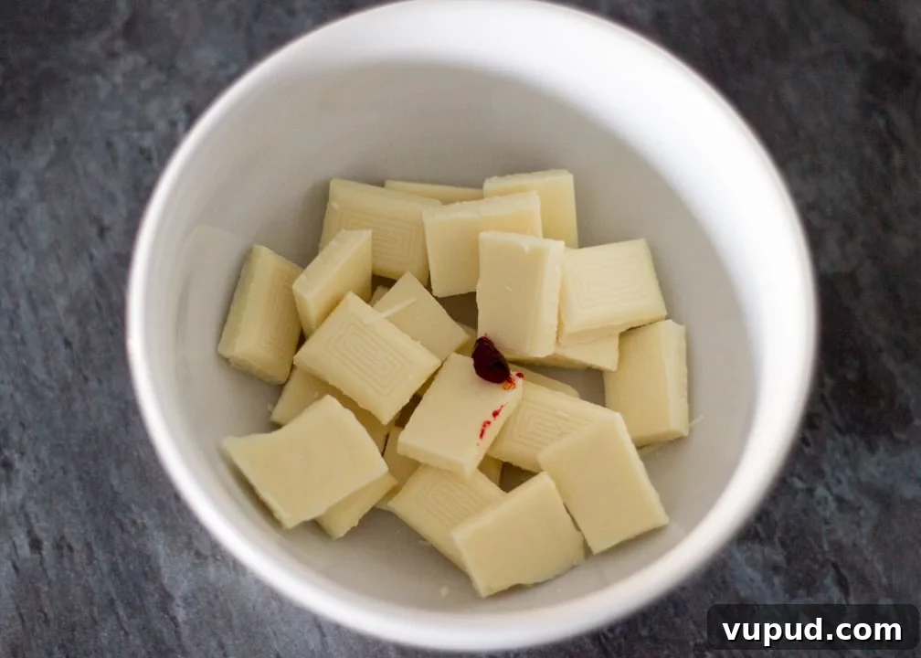 Chocolate Orange Caramel Shortbread Recipe — Zesty Caramel Slice 5 White chocolate in a bowl with orange food colouring