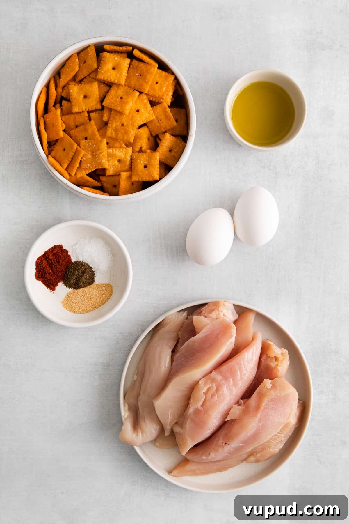 These easy Cheez-It breaded chicken fingers take one of your favorite snacks and turn it into a crispy, cheesy chicken masterpiece! Made in the air fryer in minutes. Ingredients for cheez-it breaded chicken fingers in bowls.