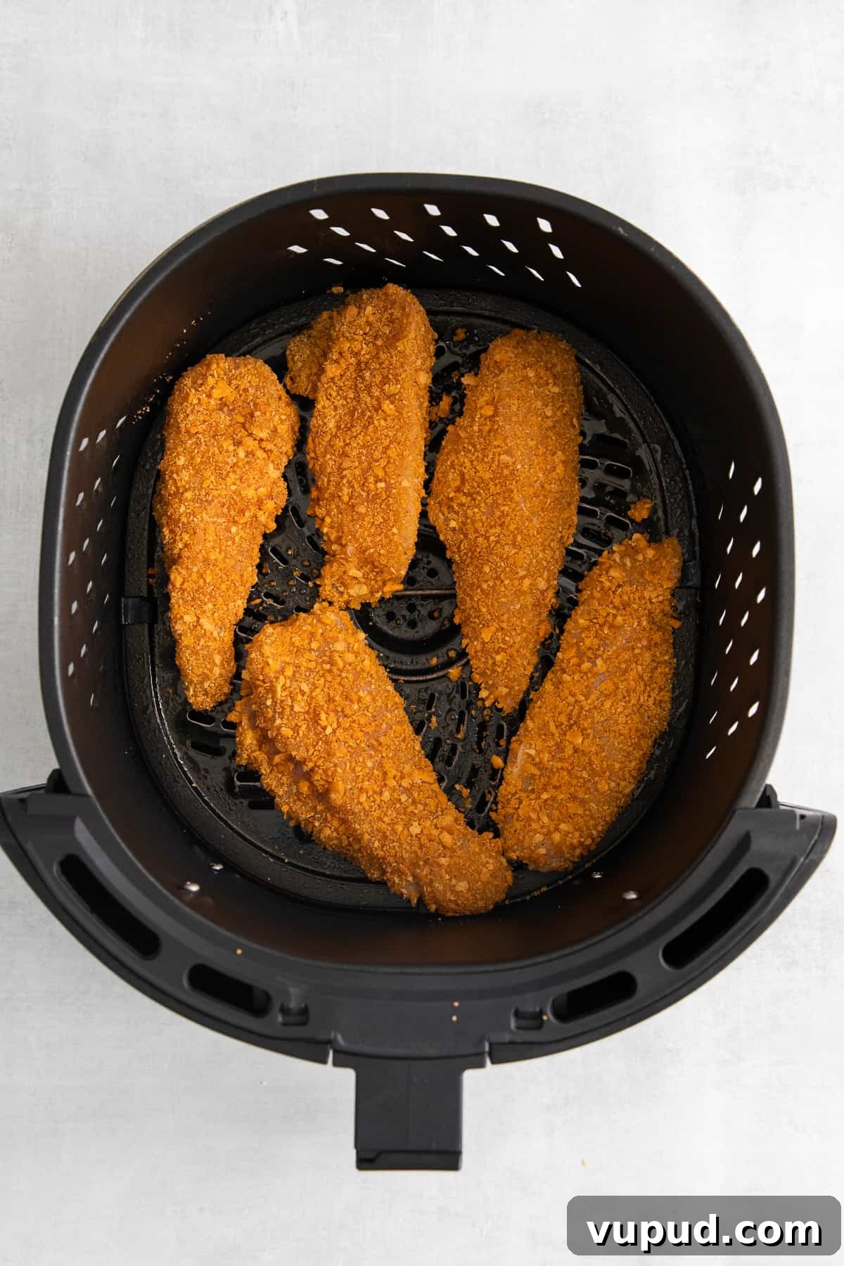 These easy Cheez-It breaded chicken fingers take one of your favorite snacks and turn it into a crispy, cheesy chicken masterpiece! Made in the air fryer in minutes. Cheez-it breaded chicken fingers in an air fryer.