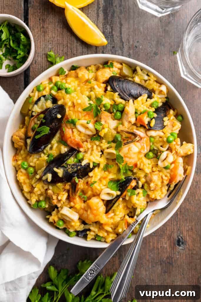 Ultimate Instant Pot Paella: Quick Spanish Rice & Seafood Recipe 3 Overhead view of a plate of Instant Pot paella on a wooden tabletop.