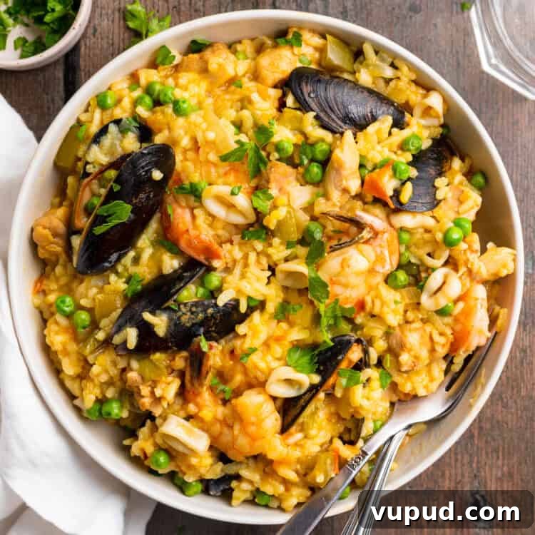 Ultimate Instant Pot Paella: Quick Spanish Rice & Seafood Recipe 4 Overhead view of a plate of Instant Pot paella on a wooden tabletop.