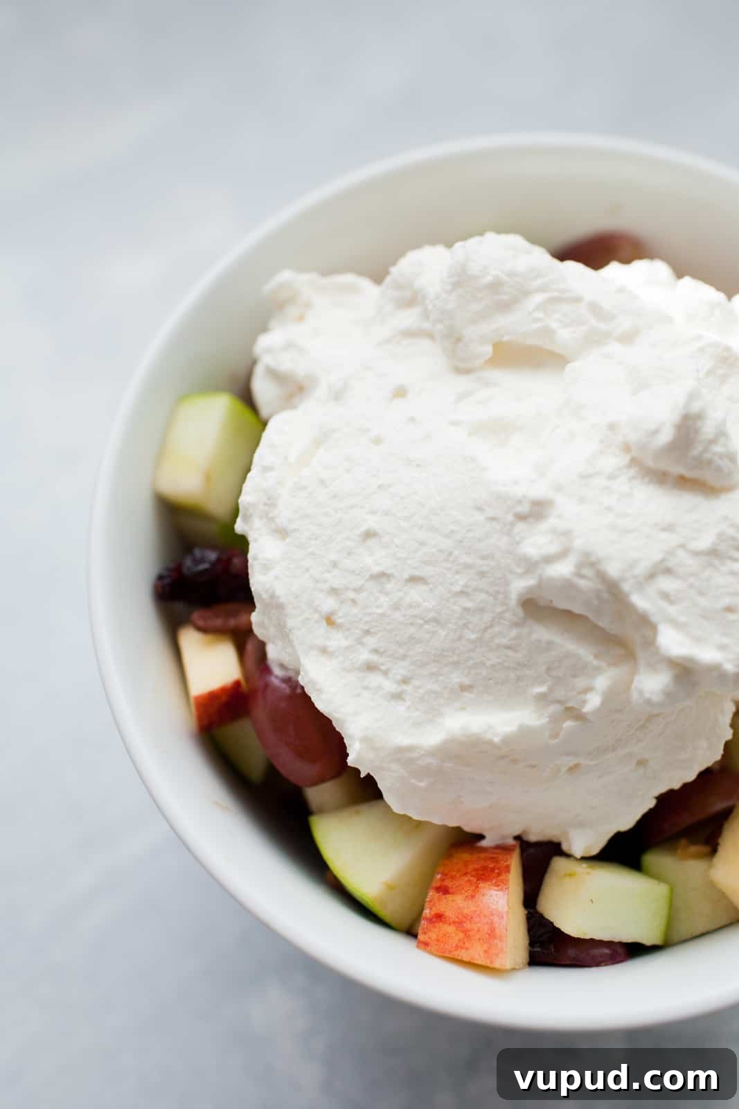 How to Make Perfect Homemade Whipped Cream at Home 6 a bowl of fruit salad with a scoop of homemade whipped cream