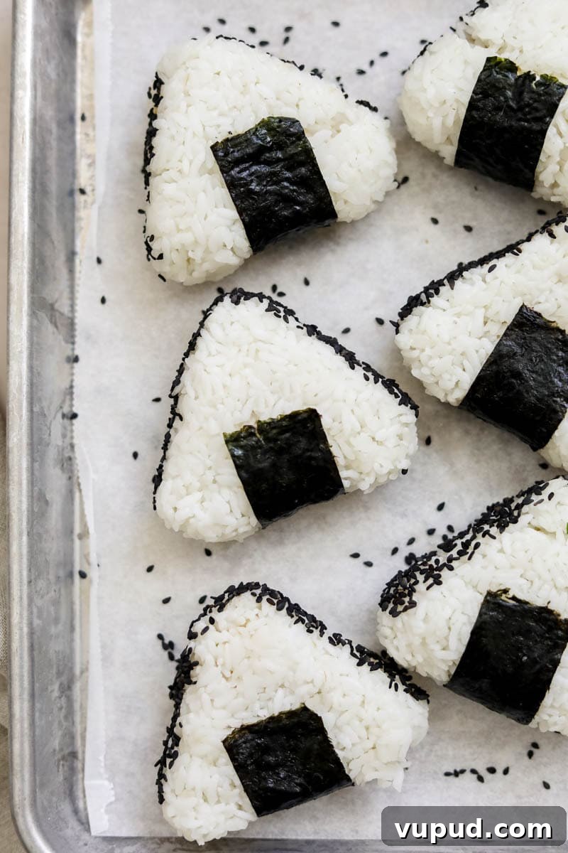 Spicy Tuna Onigiri Recipe — Authentic Japanese Rice Balls 2 Spicy Tuna Onigiri made with rice and nori and formed in small triangles.
