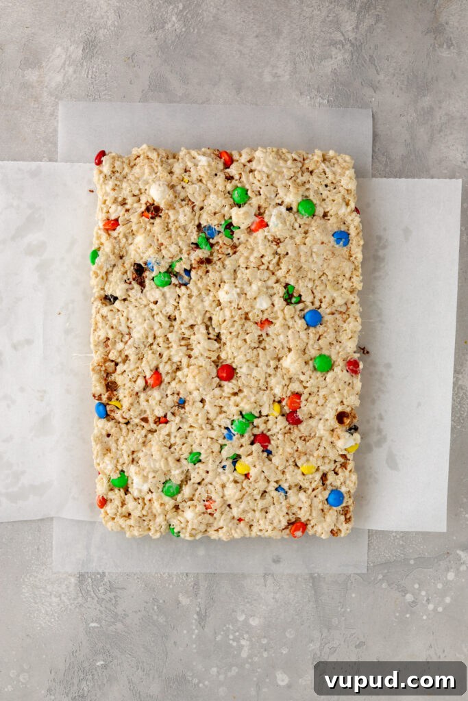 M&M Rice Krispie Treats Recipe: Colorful No-Bake Snack 12 A batch of M&M Rice Krispie Treats on parchment paper.