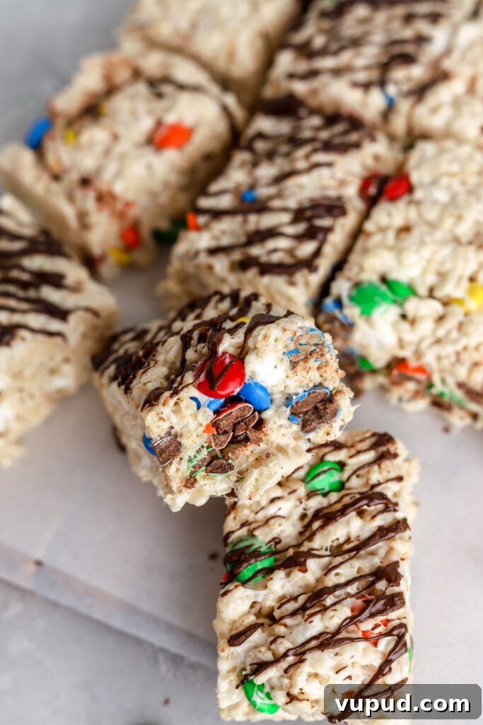 M&M Rice Krispie Treats Recipe: Colorful No-Bake Snack 13 Rice Krispie squares filled with M&Ms and drizzled with chocolate.