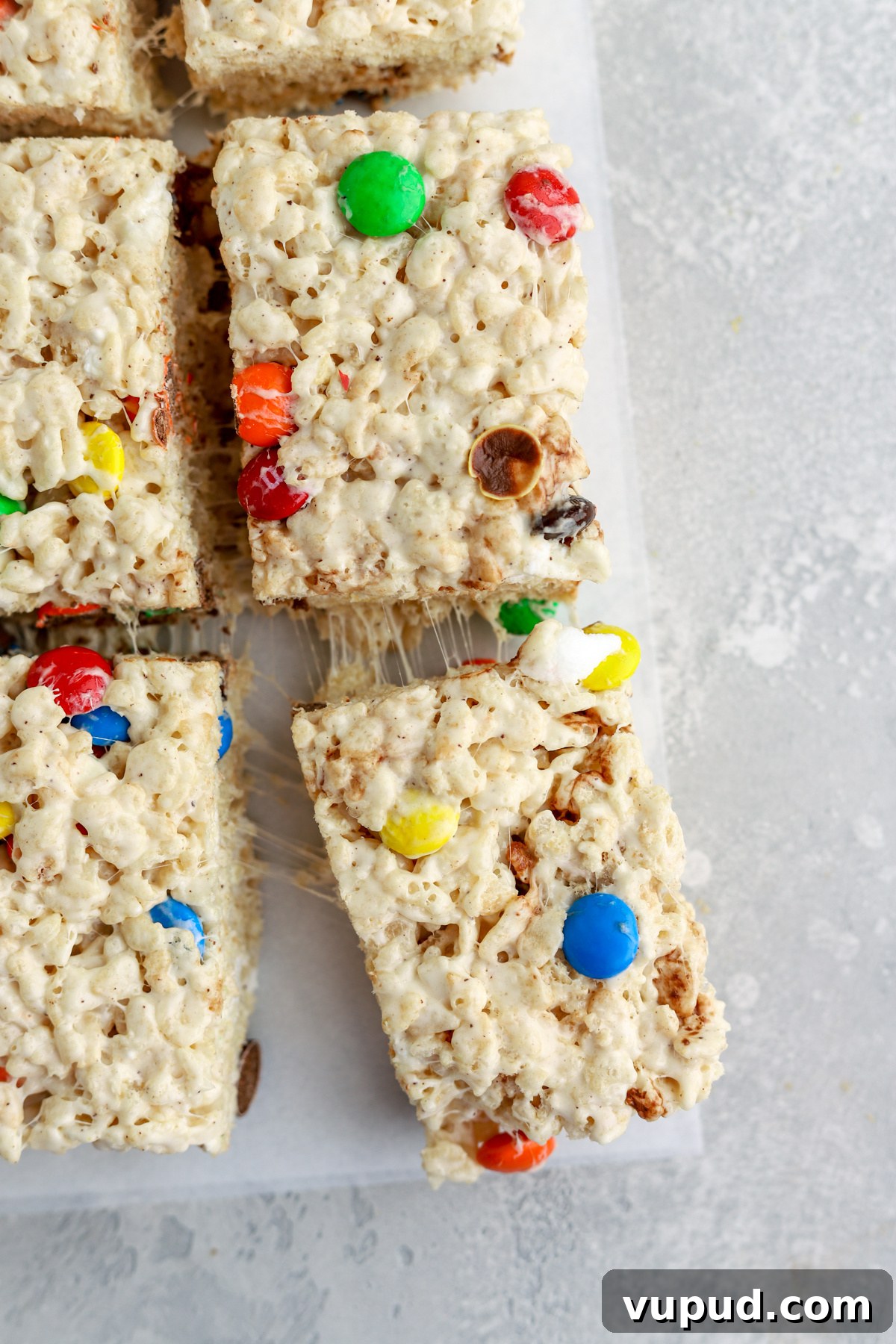 M&M Rice Krispie Treats Recipe: Colorful No-Bake Snack 3 Rice krispie treats with M&Ms cut into pieces.