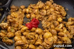 Indian Mushroom Bhaji Recipe: Flavorful Mushroom Curry Guide 11 Tomato puree added to the mushroom bhaji cooking in a frying pan