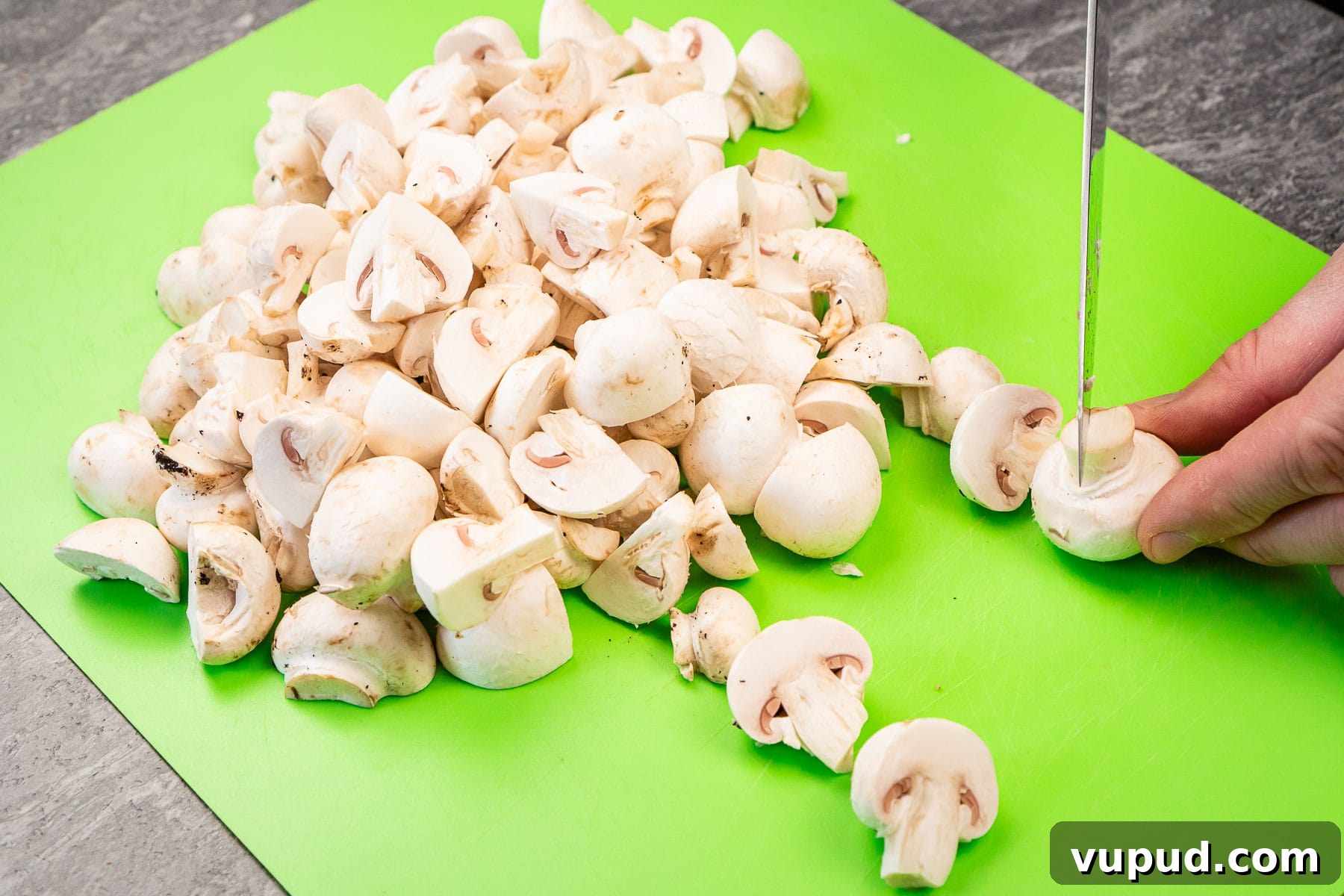 Indian Mushroom Bhaji Recipe: Flavorful Mushroom Curry Guide 14 Chopping up closed cup mushrooms on a green chopping board