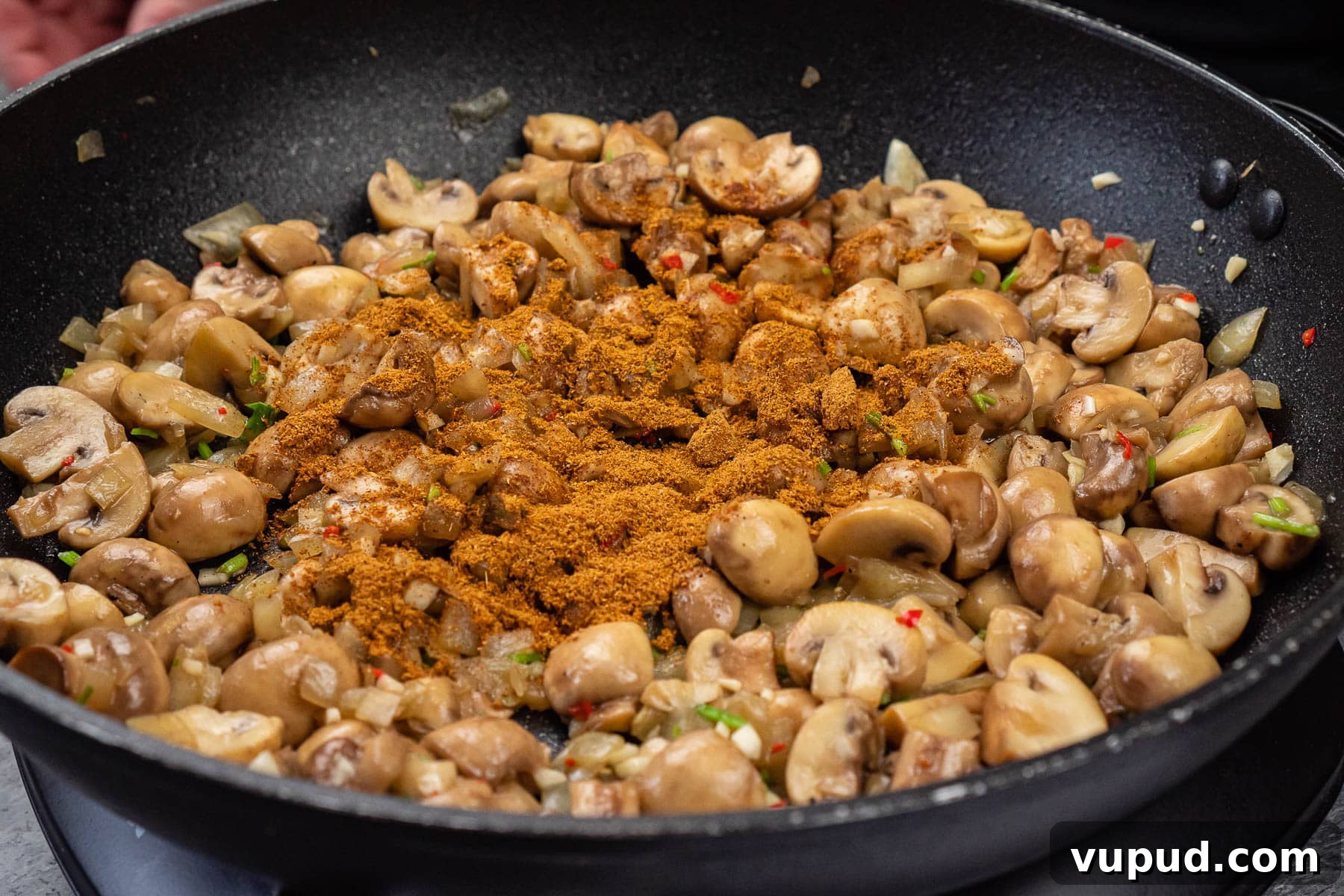 Indian Mushroom Bhaji Recipe: Flavorful Mushroom Curry Guide 18 Chopped mushrooms, chopped chilli, chopped onion, garlic, coriander stems and curry powder in a frying pan