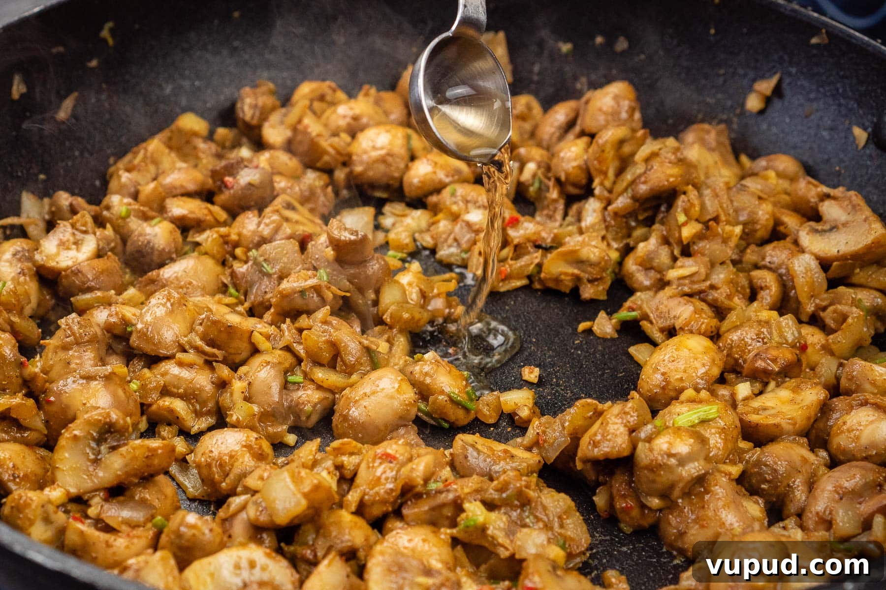Indian Mushroom Bhaji Recipe: Flavorful Mushroom Curry Guide 20 Pouring white wine vinegar to the mushroom bhaji cooking in a frying pan