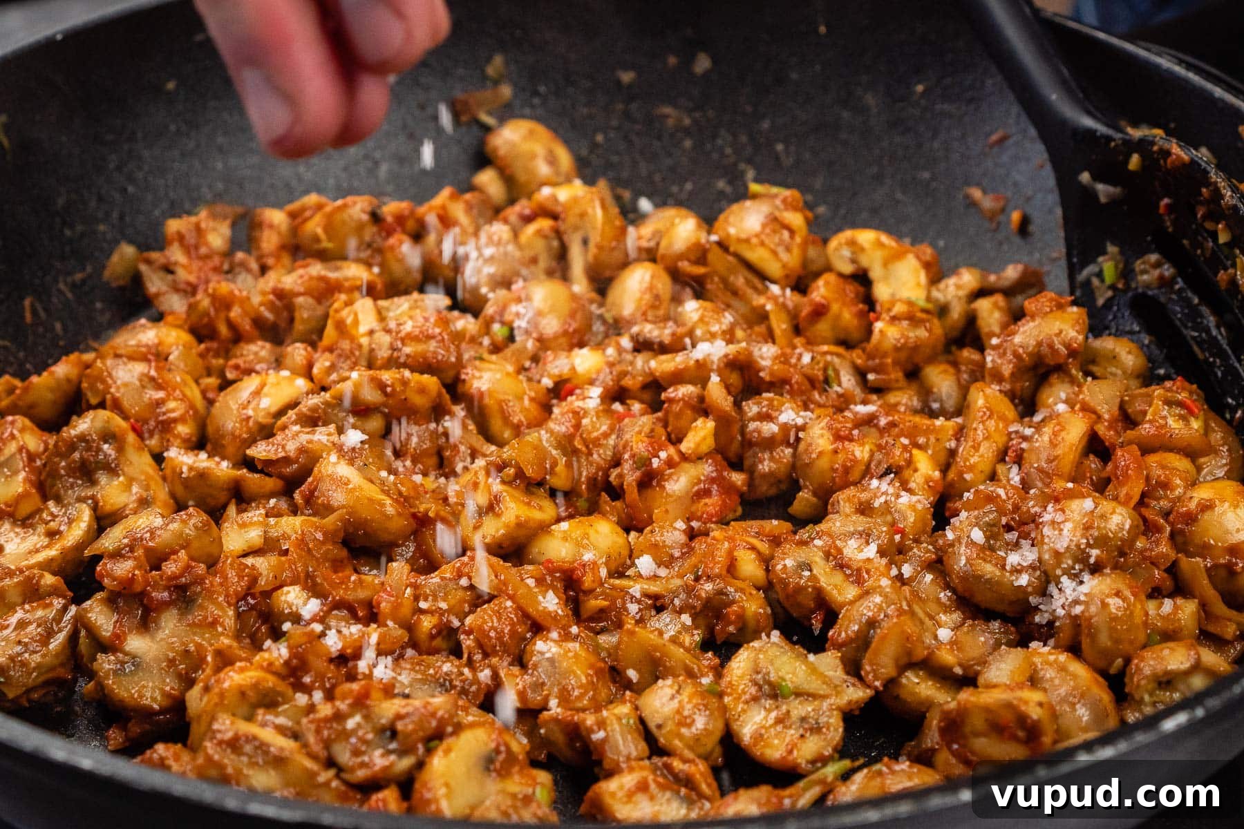 Indian Mushroom Bhaji Recipe: Flavorful Mushroom Curry Guide 22 Sprinkling salt over the mushroom curry cooking in a frying pan