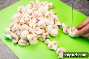 Indian Mushroom Bhaji Recipe: Flavorful Mushroom Curry Guide 4 Chopping up closed cup mushrooms on a green chopping board