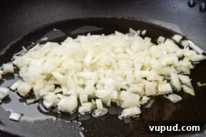 Indian Mushroom Bhaji Recipe: Flavorful Mushroom Curry Guide 6 Chopped onion being fried in oil in a pan