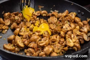 Indian Mushroom Bhaji Recipe: Flavorful Mushroom Curry Guide 10 English mustard being added to the mushroom bhaji cooking in a frying pan