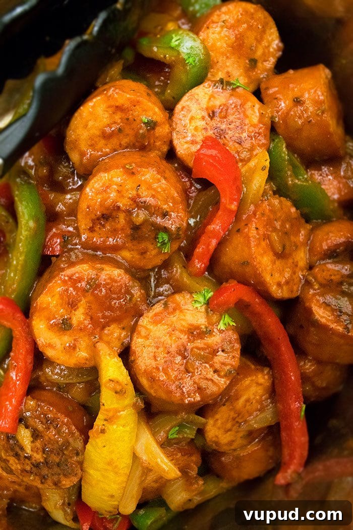 Instant Pot Italian Sausage and Peppers Recipe for Quick Dinners 3 Tongs Full of Italian Sausage, Peppers and Onions.