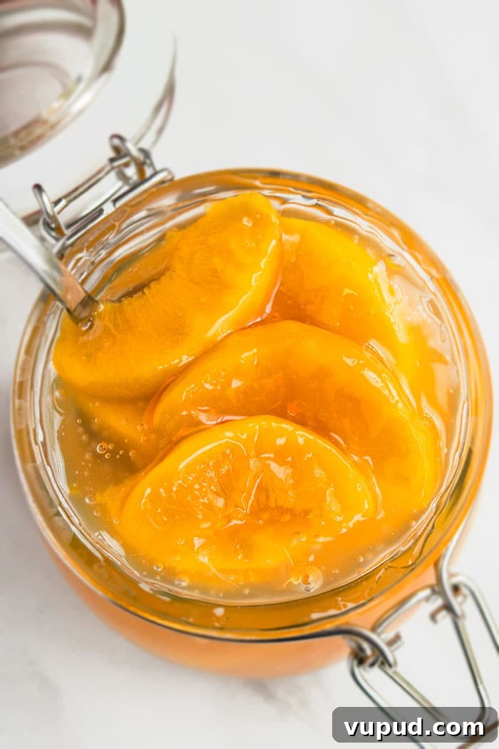 Homemade Pie Filling in Glass Jar With Silver Spoon on White Marble Background.