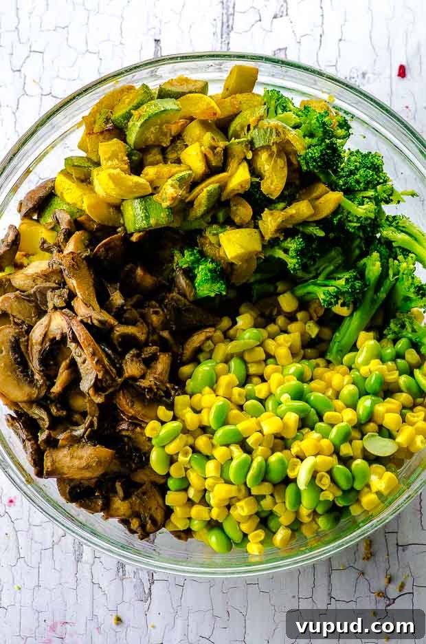 Veggie-Packed Quinoa Fried Rice Recipe for Flavorful Meals 5 Sautéed broccoli, zucchini, yellow squash, corn and edamame, in a bowl.