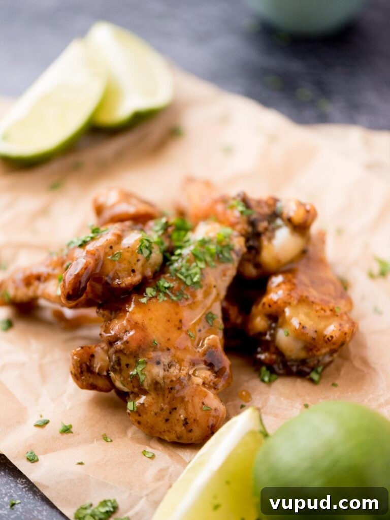 Tequila-Lime Chicken Wings: Zesty Grilled Wing Recipe 11 Lime wedges on parchment paper next to tequila lime wings.